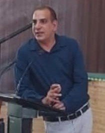 Portrait of Dr. Kapoor wearing traditional attire with academic books in background